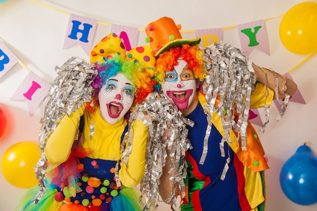 Premium Photo | Cheerful emotional clowns at the party with paper disco