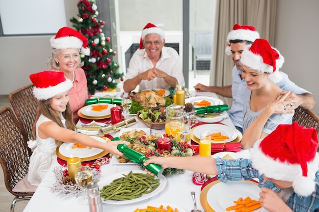 クリスマスディナーのテーブルで陽気な家族 プレミアム写真