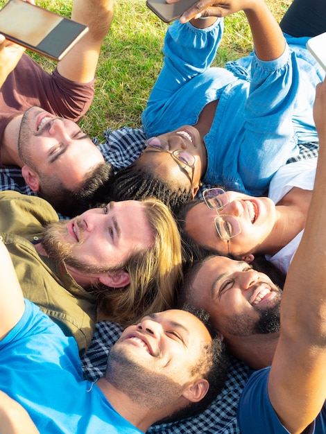 free-photo-cheerful-friend-lying-and-holding-smartphones