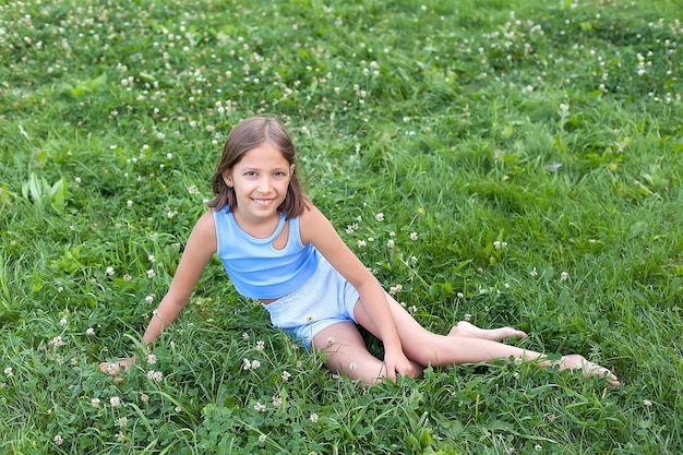 Premium Photo | A cheerful girl of 8-10 years old plays on a green ...