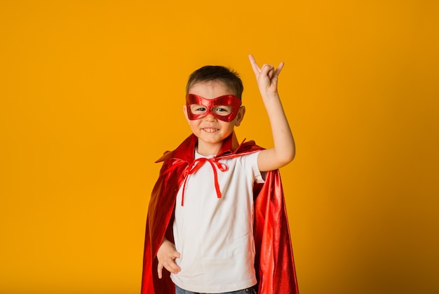 Premium Photo | Cheerful little boy in a hero costume on a yellow ...