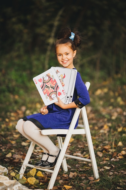 Premium Photo | Cheerful little girl with playing cards