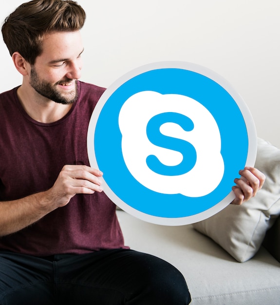 Cheerful man holding a skype icon Free Photo