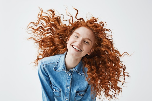 Cheerful Redhead Woman With Flying Curly Hair Smiling