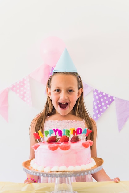 Free Photo | Cheerful surprised birthday girl standing behind cake and ...