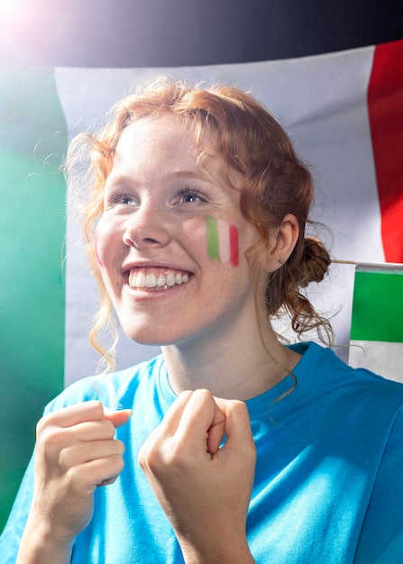 彼の顔にイタリアの旗と応援スマイリー女性 プレミアム写真