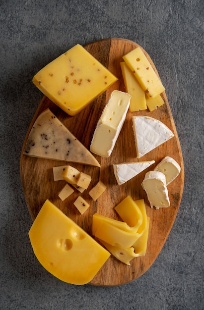 Premium Photo | Cheese platter on wooden board. cheese background. closeup.