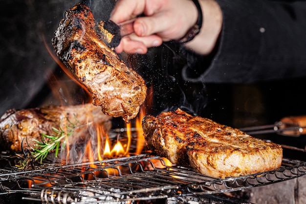 シェフがレストランで直火で肉 ビーフステーキを揚げる プレミアム写真