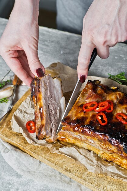 The chef cuts the pork ribs grill. Premium Photo