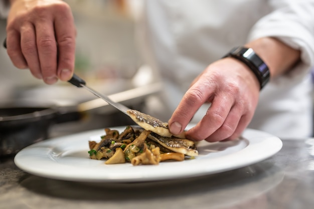 Premium Photo | Chef plating fish on vegetables getting food ready for ...