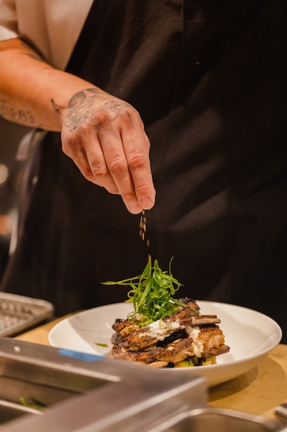 Free Photo | Chef pouring seasoning on beef stake on plate