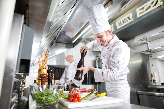 Premium Photo | Chef prepares a dish in the kitchen of restaurant