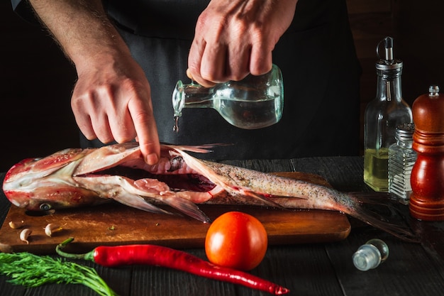 Premium Photo | The chef prepares fresh fish bighead carp with add ...