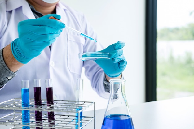 Chemist is analyzing sample in laboratory with equipment and science experiments glassware Premium Photo