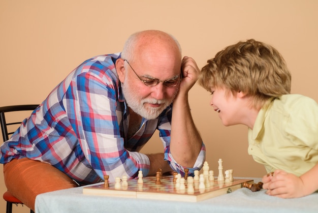 Дед с внуком играют в шашки. Дед и внук играют в шахматы. Дедушка учит внука. Дед с внуком играют в шашки дед. Картинки как дедуля играет с внуком шахматы.