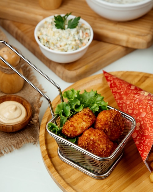 Free Photo Chicken nuggets in batter on a wooden board