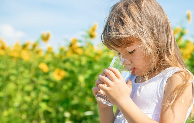 Premium Photo | A child drinks water on the background of the field