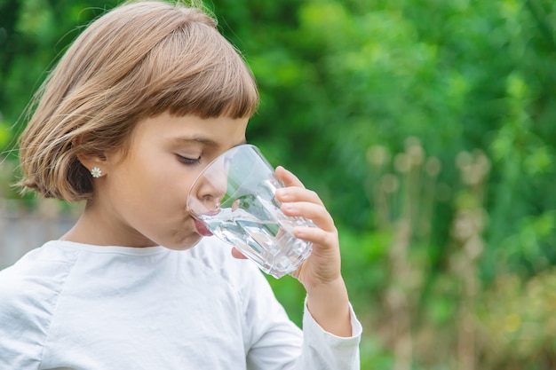 Premium Photo | Child drinks water from a glass