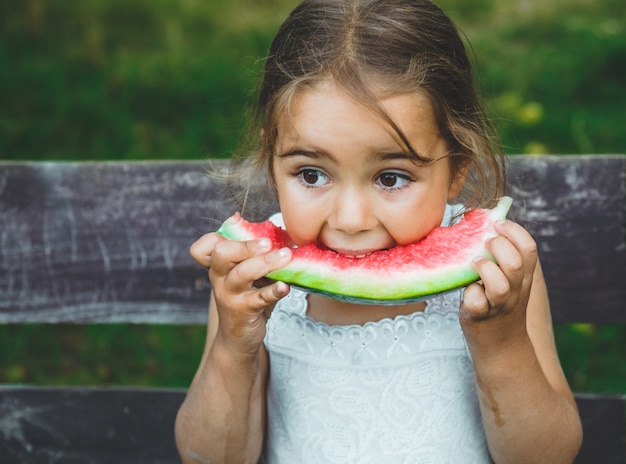 Premium Photo | Child eating watermelon in the garden. kids eat fruit ...