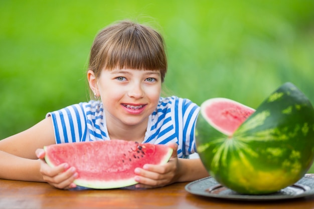 Premium Photo | Child eating watermelonpre teen girl in the garden ...