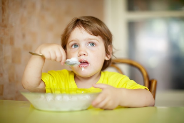 Child himself eats dairy with spoon Free Photo