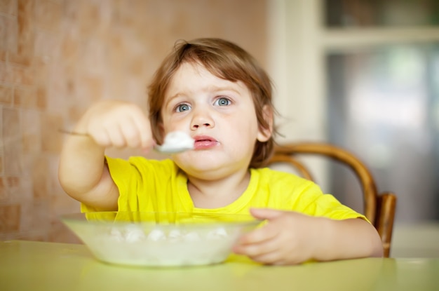 child himself eats with spoon Free Photo