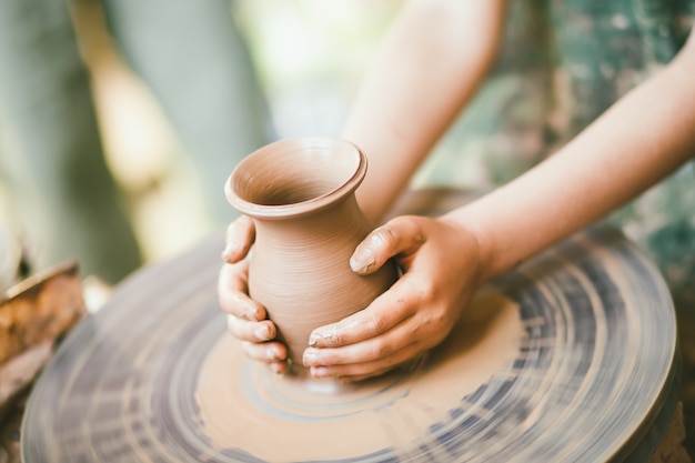 Premium Photo Child learning to sculpt a clay pot Premium Photo Child learning to sculpt a clay pot