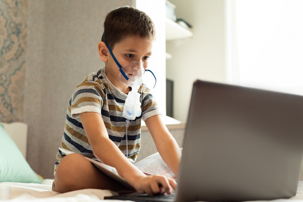 Premium Photo | A child learns home lessons in an oxygen mask with a ...