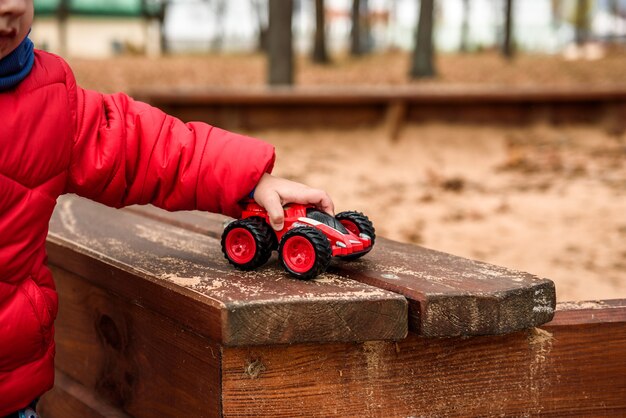 遊び場でおもちゃの車で遊んでいる子供 プレミアム写真