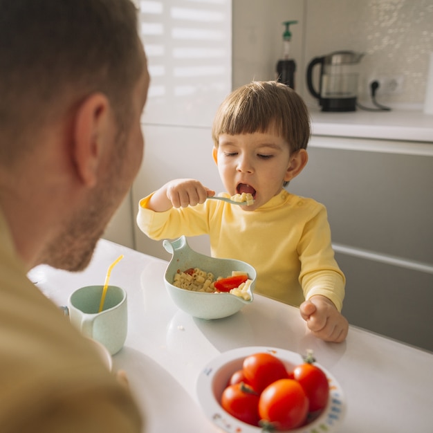 スプーンで穀物を取って食べる子供 無料の写真