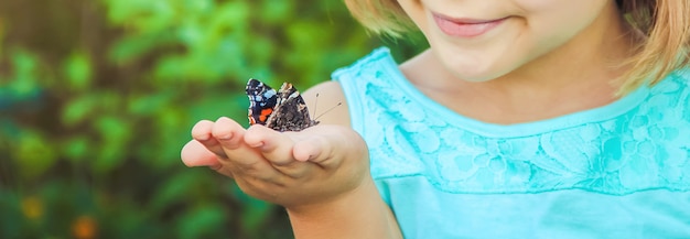 Child with a butterfly. photo. nature. Premium Photo