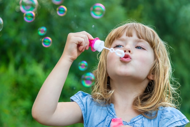 Premium Photo | Children blow bubbles in the street. selective focus ...