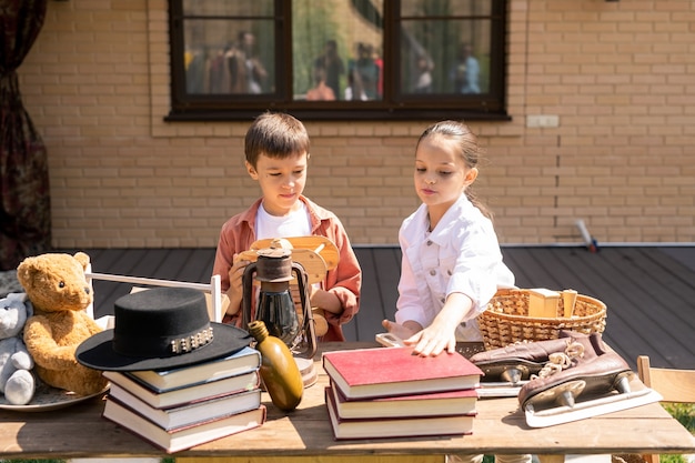 Children buying toy and book at garage sale Premium Photo