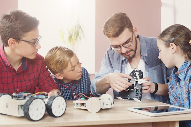 Premium Photo | Children creating robots with teacher at school, stem ...