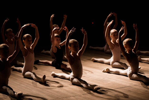 Premium Photo | Children doing splits while warming up on the stage