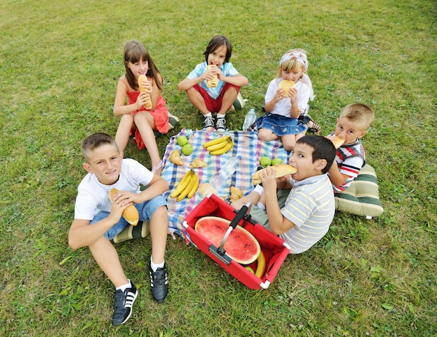 Premium Photo | Children having picnic on meadow in circle