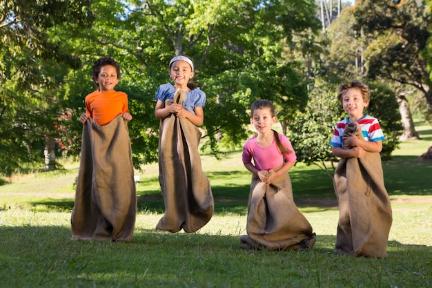 Premium Photo | Children having a sack race in park