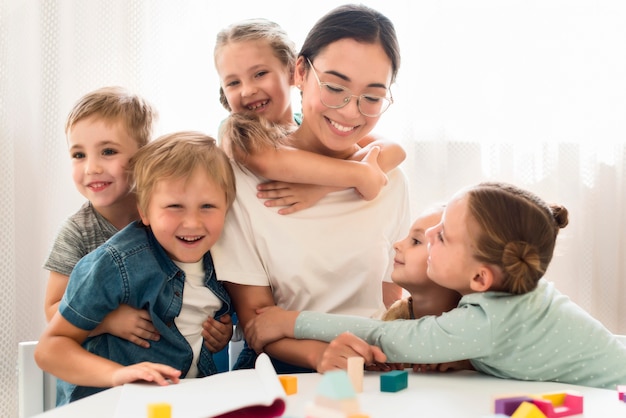 Children hugging their teacher Free Photo