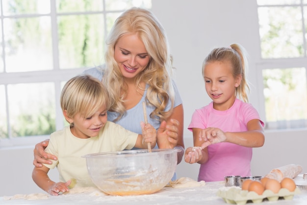 Premium Photo | Children mixing dough with their mother
