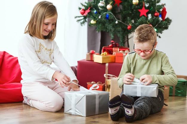 Free Photo | Children opening christmas presents on the floor