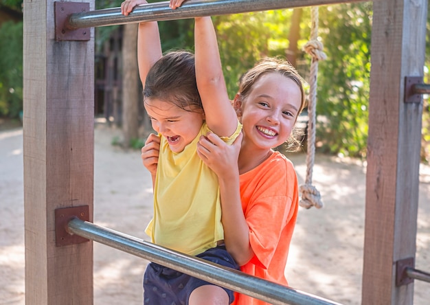 Premium Photo | Children play in the playgraund. the older girl helps ...