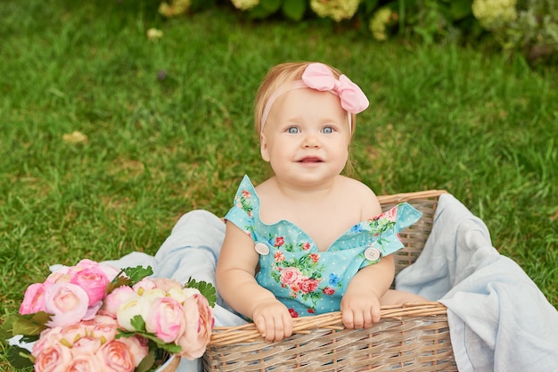 子供の保護の日 公園で女の赤ちゃんは夏のピクニックにバスケットに座っています プレミアム写真