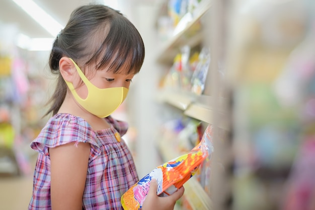 Children read dessert candy labels to see the components and the expiration date Premium Photo