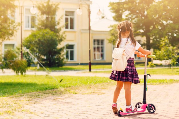 Children riding scooters on their way to school Premium Photo