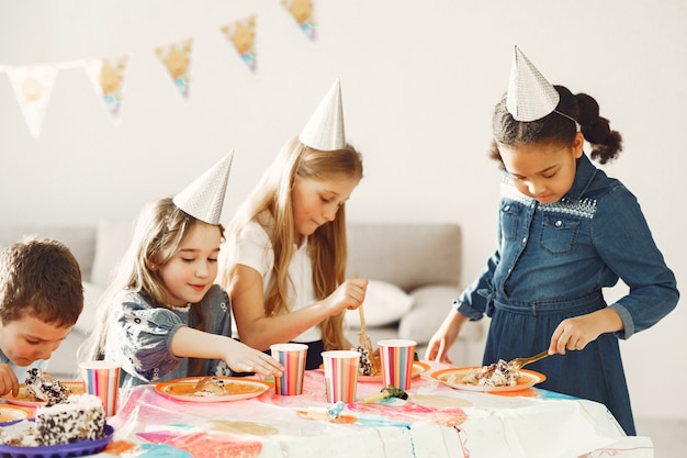 装飾された部屋での子供の面白い誕生日パーティー ケーキと風船で幸せな子供たち 無料の写真