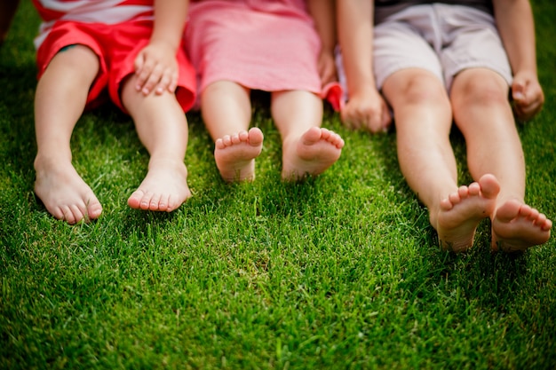 Childrens Legs On The Grass Bare Legs Of Little Girls Sitting On The