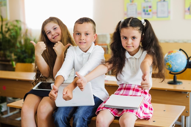 Children Sitting On School Desk Gesturing Free Photo