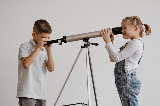 Free Photo | Children using a telescope in class