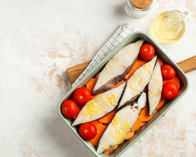 Premium Photo Chilled halibut steaks in a baking dish with tomatoes