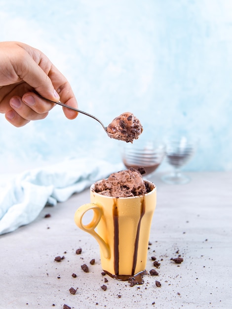 Download Premium Photo Chocolate Brown Ice Cream In A Regular Yellow Mug And Spoon On Blue With Topping And Crumbs